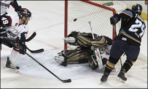 The Walleye's Zack Torquato sneaks a shot past Riley Gill to cut the Kalamazoo lead to 3-2 before 7,446 fans at the Huntington Center.