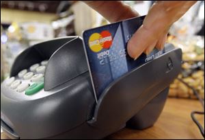 A customer swipes a MasterCard debit card through a machine while checking-out at a shop in Seattle.