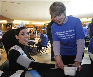 Becky Minger, 23, of Sylvania, who is Miss Ohio 2010, has her blood pressure checked by Kidney Foundation volunteer Debbie Mills.