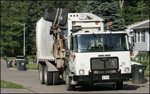 An automated Toledo trash pickup truck empties a trash can in Toledo.