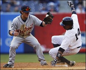 Detroit second baseman Will Rhymes attempts to tag out New York's Curtis Granderson (14) as he steals second base.