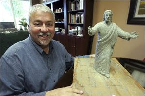 Ron Carter, church administrator for Solid Rock Church in Monroe, Ohio, displays the model of the new statue 