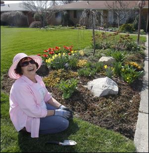 Toledoan Donna Coleman McCarty, who dug into her hobby in earnest 40 years ago, tends to her Shoreland Avenue garden.