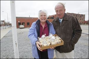 Ann and Bill Albright charge $5 to park in their unlicensed lot at Lafayette and Superior streets. The Albrights of Swan Creek Candle Co. give a candle and a discount coupon to each person who parks in their lot.