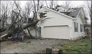 A large tree slammed into this house on Sugarbush Road after Kelli Gerke had run to the basement. Her husband, Ken, saw the tree crash onto the couch where his wife had been sitting just moments before.