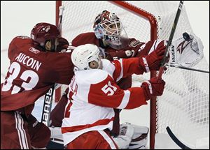 Phoenix Coyotes' Ilya Bryzgalov, top, makes a glove save on a shot by Detroit Red Wings' Valtteri Filppula (51) as Coyotes' Adrian Aucoin (33) defends during the second period of Game 4 in Arizona.