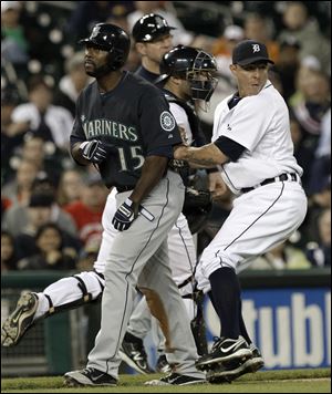 Detroit Tigers third baseman Brandon Inge, right, tags out Seattle Mariners' Milton Bradley who was caught trying to score.