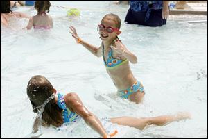 Madison Theis, right, splashes around the water with friend Kelsey Reece, left, while spending the afternoon at Pickford Pool last July.