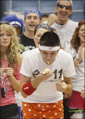 Senior Aleks Todorov leans forward, stuffing in a second banana, while the crowd cheers him on.