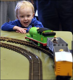 A model train set up for National Train Day meets the approval of Ethan Eidy, 3, of Sylvania. The daylong event included a talk by a railroad engineer that emphasized safety. Sponsors estimated attendance would total 5,000 for the day.