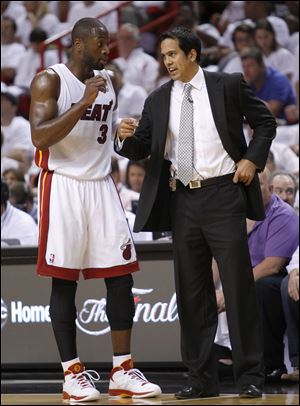 Miami Heat coach Erik Spoelstra, right, talks with Dwyane Wade during the first half of Game 1 of a second-round NBA playoff basketball series against the Boston Celtics Sunday in Miami. 