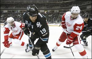 San Jose Sharks center Joe Thornton (19) is defended next to the boards by Detroit Red Wings center Pavel Datsyuk, left, and defenseman Ruslan Salei (24) during the first period in Game 2 of an NHL Western Conference semifinal Stanley Cup playoff hockey series game in San Jose, Calif., Sunday. 