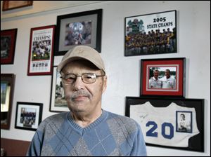 Larry Christy, long-time broadcaster at WMTR radio in Archbold, with sports memorabilia at Icky's restaurant in Archbold. He recently retired because of a rare kidney disorder.