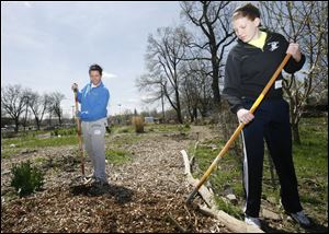 Katie Welling, 16, of Bedford Township, left, and Lindsay Steinbauer, 16, of South Toledo help by raking mulch.