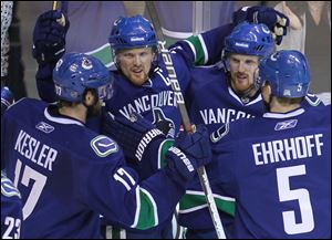 Vancouver Canucks' Daniel Sedin, second from left, celebrates his goal with teammates, Ryan Kesler, Henrik Sedin, and Christian Ehrhoff, during the third period of Game 2 of the NHL hockey Stanley Cup playoffs Western Conference finals, Wednesday in Vancouver. 