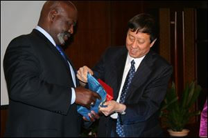 Toledo Mayor Mike Bell receives a gift from Zhu Naizhen, vice mayor of Mudanjiang, during an hours-long meeting to discuss business opportunities. The two promised to visit each other’s cities this year.