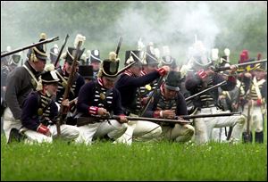 Soldiers reload their muskets during a past re-enactment of the battle at Fort Meigs.