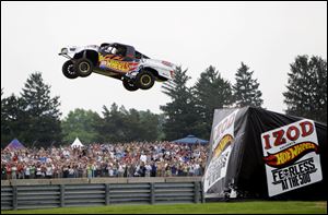 Professional stunt driver Tanner Faust flies through the air on his way to setting a new world record by jumping 332 feet in a Pro 2 truck at the Indianapolis Motor Speedway before the Indianapolis 500 Sunday. 