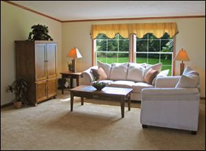 The great room’s ceiling and windows are framed in attractive natural oak.