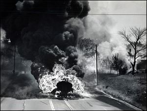 A trailer of a Standard Oil tanker truck carrying 7,900 gallons of gasoline, burns after overturning on the Trail near Vinton Street in South Toledo on June 10, 1961.