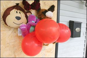 A few stuffed animals and balloons tacked to the boarded-up front window of the home on Grand Avenue where Montelle Taylor lived are an impromptu memorial for the 17-year-old youth who died of gunshot wounds.