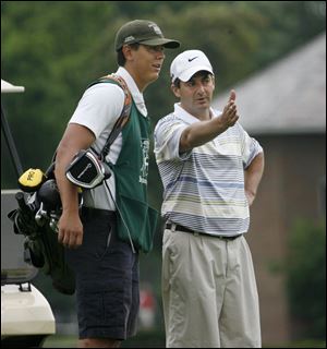 Caddie Derrick Creque talks strategy with golfer Jeff Judis at Toledo’s Inverness Club, where there are 300 caddies on staff. Creque is one of several Evans Scholars at the club. He attends Miami University.