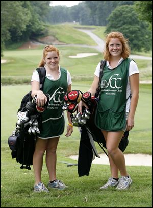 Katie, left, and Emilee Knakiewicz caddie at Sylvania Country Club. Their scholarships help them go to Michigan.