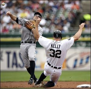 Mariners second baseman Jack Wilson, left, turns the ball after getting the force-out on the Tigers' Don Kelly at second base to complete a double play on Brennan Boesch at first in the first inning.