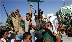 In this photo taken on a government-organized tour an armed Libyan security officers sit on top of a car as people rally at the Green Square in Tripoli, Libya, on Friday.