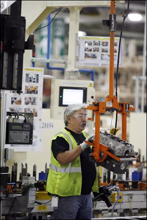 Colin Reaume, of Dundee, moves engine blocks to the line at Global Engine Manufacturing Alliance plant.