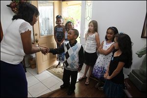 Densie Cardwell, of Toledo teaches Akil Jones, 6 a proper greeting and handshake with other classmates, from left, Michaela Sims, 9, of Toledo,  Legaci Jones, 9, of Toledo; Sophie King, 8, of Maumee; Taylor Halsey, 8, of Springfield Township; and Sydney Pugsley, 9, of Perrysburg. 