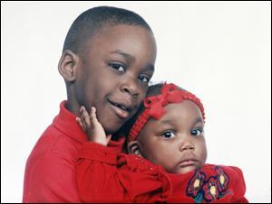 A young Montelle Taylor sat for a formal portrait with his half-sister, A’Bria Johnson, now 15, when she was a baby.