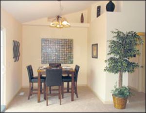 A tall ceiling and plant shelves add drama to the dining room.