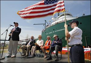 Cody Ide, 12, of the Toledo Maritime Academy, holds the U.S. flag as Paul LaMarre III, executive director of the museum ship, addresses the crowd.