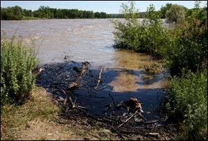 Oil swirls in a flooded gravel pit in Lockwood, Mont., after a pipeline break Saturday. The ExxonMobil pipeline that runs under the Yellowstone River near Billings in south-central Montana ruptured and dumped an unknown amount of oil into the waterway, prompting temporary evacuations along the river.