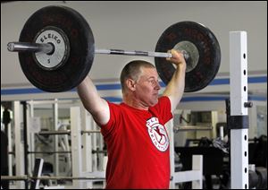 Weightlifter Todd Baden, who has been weightlifting for 17 years, begins his lifting routine with a warmup exercise based in part on the clean-and-jerk maneuver.