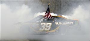 Ryan Newman does a burnout while holding the American flag Sunday after winning at New Hampshire Speedway.