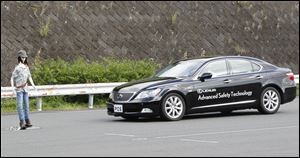 A Toyota car stops automatically before a dummy during a precollision test in a demonstration of new safety technologies in Japan.