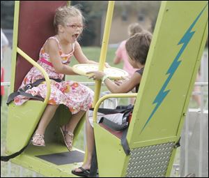 Madeline Merryman, 6, of Toledo, and Matthew Kowalski, 10, of Lambertville, on a ride at the Regina Coeli 2011 Summer Festival.