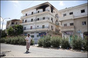 A Libyan rebel runs for cover from sniper fire during fighting in the town of Zawiya, roughly 50 km (30 miles) west of Tripoli, Libya, Tuesday, Aug. 16, 2011. The day Libyan rebels advanced into the strategic city of Zawiya, Moammar Gadhafi's forces clamped down on the local hospital. They forced doctors to perform hours of consecutive surgeries, put snipers on the roof and an anti-aircraft gun near the entrance, two doctors who managed to escape said Tuesday.