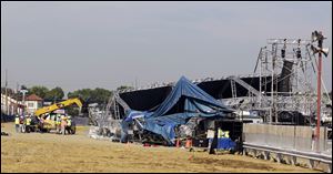 Investigators examine the stage that collapsed on Saturday at the Indiana State Fair in Indianapolis after high winds caused the structure to fall.