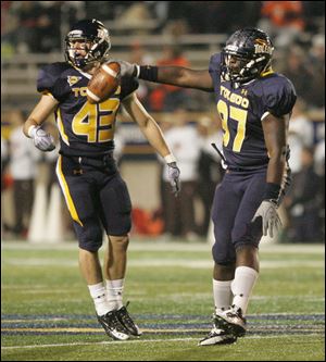 UT's Mark Singer, left, celebrates Malcolm Riley's fumble recovery during a game at UT's Glass Bowl.