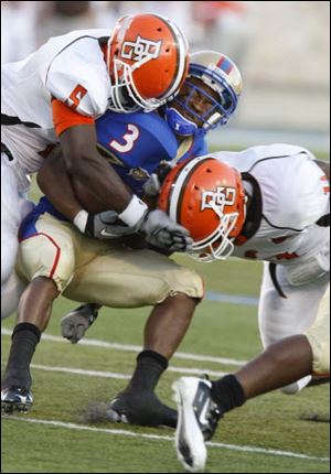 In this photo from September, 2010, Dwayne Woods, left, wraps up Tulsa’s Damaris Johnson (3).