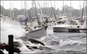 A sailboat that broke from its mooring is shoved about by the waves in New Bedford, Mass. While Tropical Storm Irene is moving into Canada, the danger is not over, President Obama said. Flooding could worsen as rivers swell.