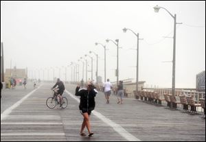 The tail end of Irene still causes trouble on the boardwalk on Long Beach as people struggle to make headway. 