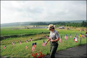 Park Ranger Wendy Clay removes items from the Flight 93 temporary memorial to be archived earlier this summer. There will be 40 trees in the memorial grove of the yet-to-be-completed Flight 93 National Memorial near Shanksville, Pa. The trees represent each of the passengers and crew members who died.