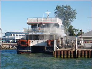 Smoke comes from below the gangplank on the Jet Express as it is docked at Put-in-Bay, Ohio, Saturday.  The fire was reported as the vessel was about a quarter mile fromPut-in-Bay. A full load of passengers were aboard, and they disembarked safely as smoke and flames could be seen under the gangplank.