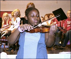 DeKayla Adams, a violin player from Waterloo Elementary School, shows the student body how to play a popular fiddle tune.