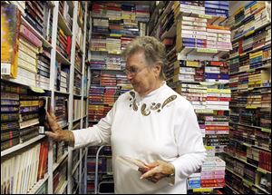 Barbara Kerschner, owner of Munchkin Book Shop puts books in their place in her Toledo, Ohio used book store.