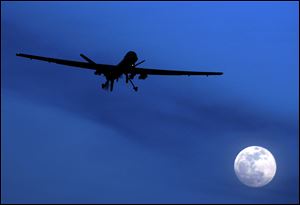 An unmanned U.S. Predator drone flies over Kandahar Air Field, southern Afghanistan, on a moon-lit night in January, 2010.